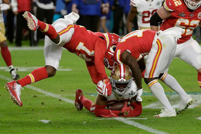 San Francisco 49ers' Tarvarius Moore, on the turf, clutches the ball after his interception. AP