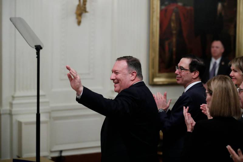 Secretary of State Mike Pompeo, joined by Treasury Secretary Steven Mnuchin, waves as he is acknowledged during an event with President Donald Trump and Israeli Prime Minister Benjamin Netanyahu in the East Room of the White House in Washington. AP Photo