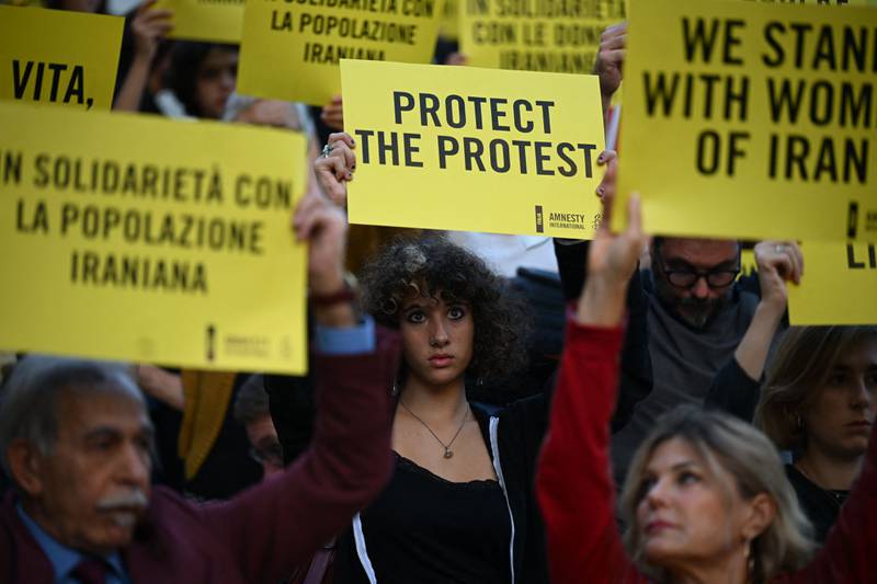 Protesters hold up placards in Rome during a demonstration in solidarity with Iranian women. AFP