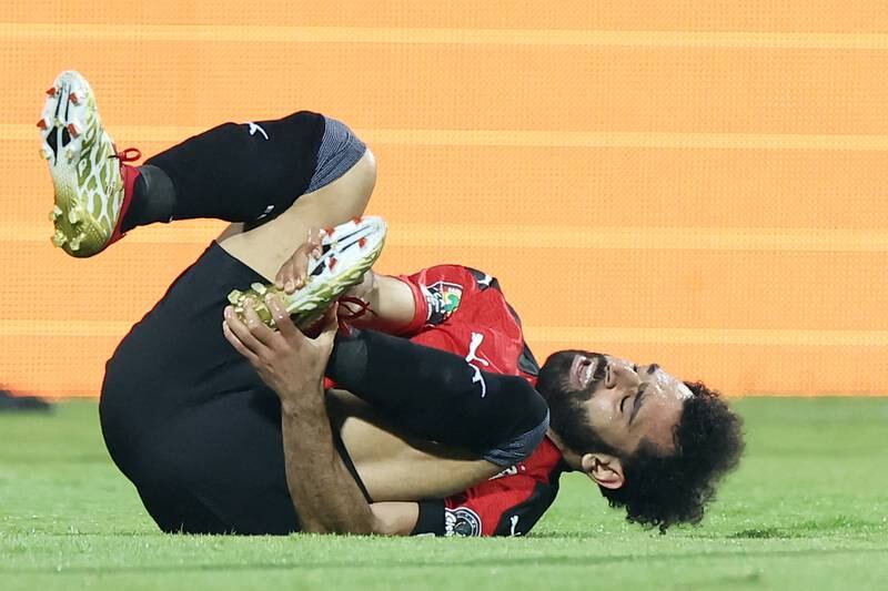 Egypt's forward Mohamed Salah lays injured after being tackled by Sudan's defender Mazin Mohamedein Alnour Mohamed during the Group D Africa Cup of Nations match at Stade Ahmadou Ahidjo in Yaounde, Cameroon on January 19, 2022. Egypt won the match 1-0. AFP