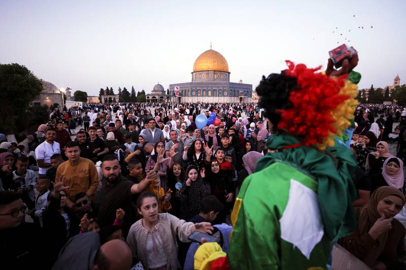 A clown throws gifts during celebrations after Palestinians performed Eid Al Fitr prayers in Jerusalem's Old City. Reuters