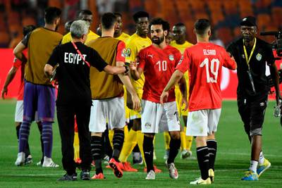 Egypt's forward Mohamed Salah (3rd-R) shakes hands with a staff member after winning the 2019 Africa Cup of Nations (CAN) football match between Egypt and Zimbabwe at Cairo International Stadium on June 21, 2019.  / AFP / Khaled DESOUKI
