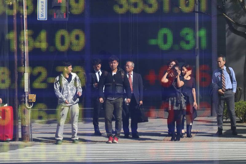 People are reflected on the electronic board of a securities firm in Tokyo, Tuesday, Nov. 5, 2019. Asian shares have advanced after the Dow Jones Industrial Average returned to a record high. Benchmarks rose across the region, led by a 2% jump in Japanâ€™s Nikkei 225 index. (AP Photo/Koji Sasahara)