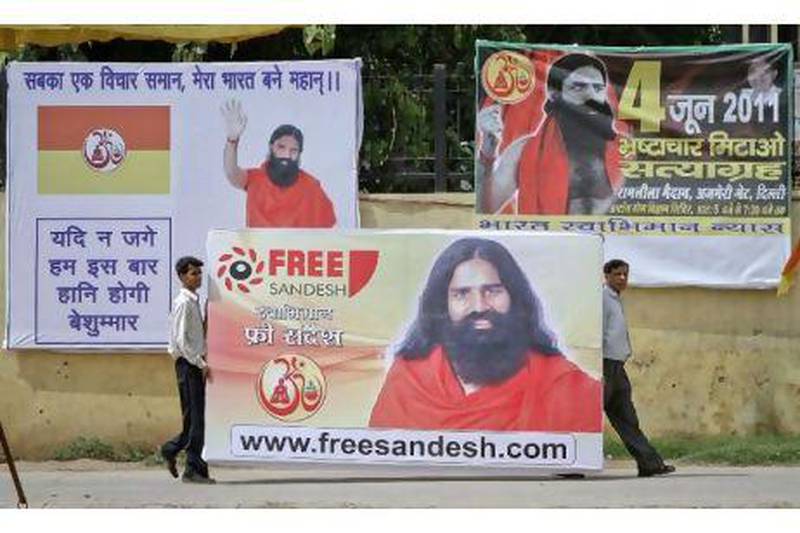 Supporters of Swami Ramdev carry his portrait before raising it in the Ramlila grounds where he was scheduled to start his anti-corruption fast in New Delhi yesterday.