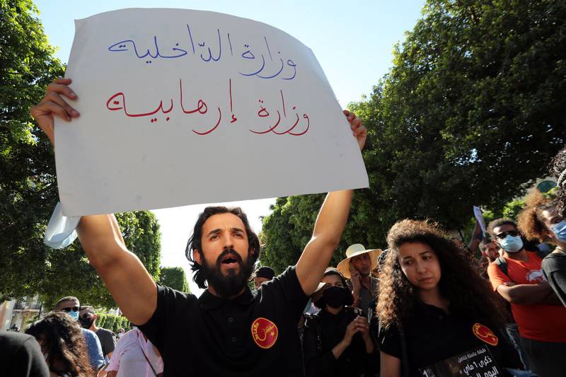 A Tunisian anti-government protest holds a placard reading in Arabic 'Interior Ministry is terrorism ministry' during a protest against police violence in Tunis. EPA