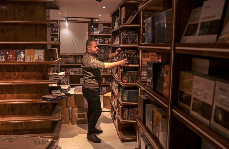 A worker arranges bookshelves ahead of the opening of the new Samir Mansour bookshop that was destroyed during last year's 11-day war between Israel and the Palestinian Hamas movement, in Gaza City.