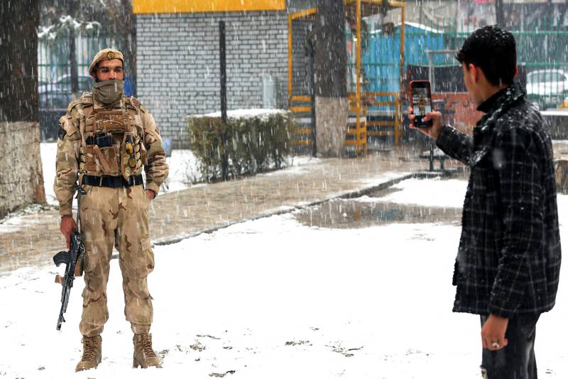 A man takes a picture of a member of the security forces in Kabul. AFP