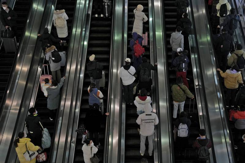 Travellers ride on the escalator at the West Railway Station in Beijing. AP Photo