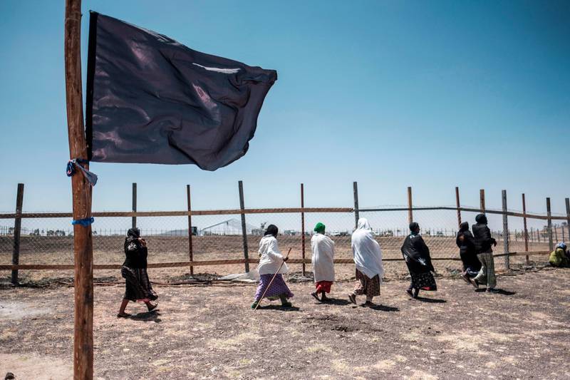A group of women walk behind a black flag during a memorial ceremony at the crash site of the Ethiopian Airlines Flight 302 airplane accident in Tulu Fara, Ethiopia.  AFP