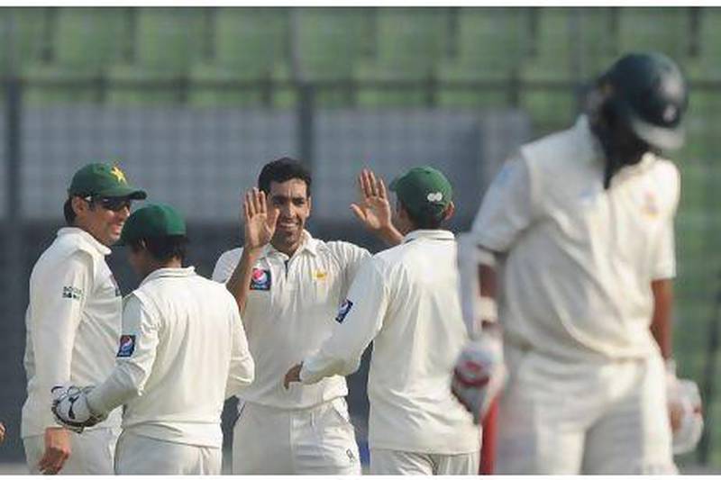 Pakistan bowler Umar Gul, centre, celebrates he dismissal of Shahriar Nafees, right. Munir uz Zaman / AFP