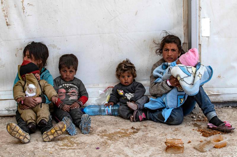 A pictured taken on March 18, 2021 shows Syrian women and children siting at the Kurdish-run al-Hol camp which holds suspected relatives of Islamic State (IS) group fighters, in Hasakeh governorate of northeastern Syria.  - Two children die every week in Al-Hol, one of the overcrowded Syrian camps where families with suspected links to the Islamic State group are stranded, Save the Children said on September 23, 2021.  The charity said many countries, including EU states, were abandoning thousands of children in their desert limbo, vulnerable to violence, fires, malnutrition and illness. 
Save the Children said a total of 40,000 children from 60 different countries were living in dire conditions in the camps of Roj and Al Hol in northeastern Syria.   AFP