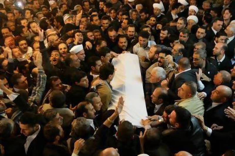 The coffin of Sunni cleric Mohammed Said Ramadan Al Bouti is carried through Damascus during his funeral on Saturday. Louai Bechara / AFP