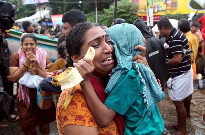 A woman cries as she holds her son after they were evacuated from a flooded area in Aluva in the southern state of Kerala, India, August 18, 2018. REUTERS/Sivaram V      TPX IMAGES OF THE DAY