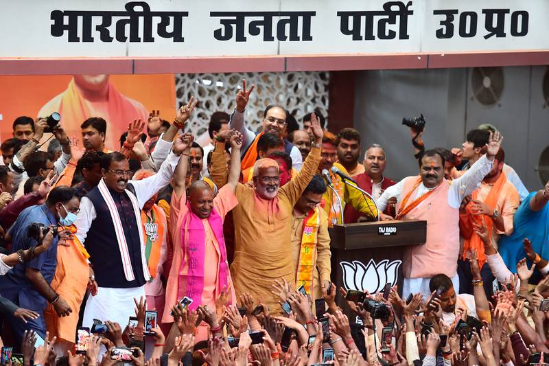Chief Minister of India's Uttar Pradesh state Yogi Adityanath (wearing pink scarf) gestures to his supporters after BJP's win, in Lucknow. AFP
