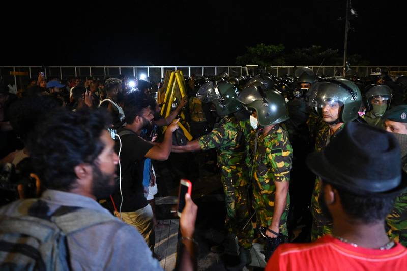 Anti-government protesters speak with members of Sri Lankan security forces. AFP