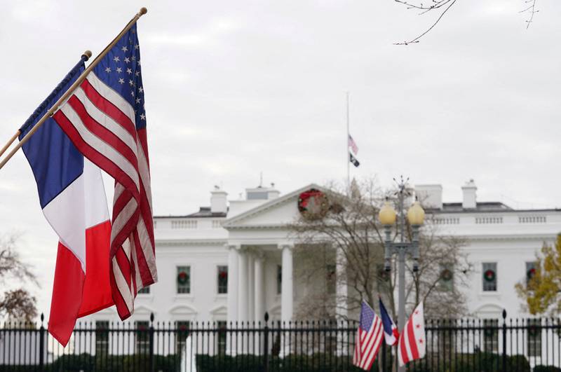 A French flag flies alongside the US  flag in front of the White House in preparation for this week's state visit by Mr Macron. Reuters