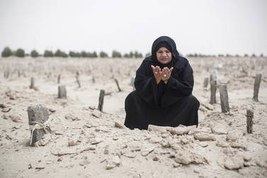 Sheikha Salem prays at her daughter’s grave in Baniyas. She quit a Government job to become a body washer. Mona Al Marzooqi / The National