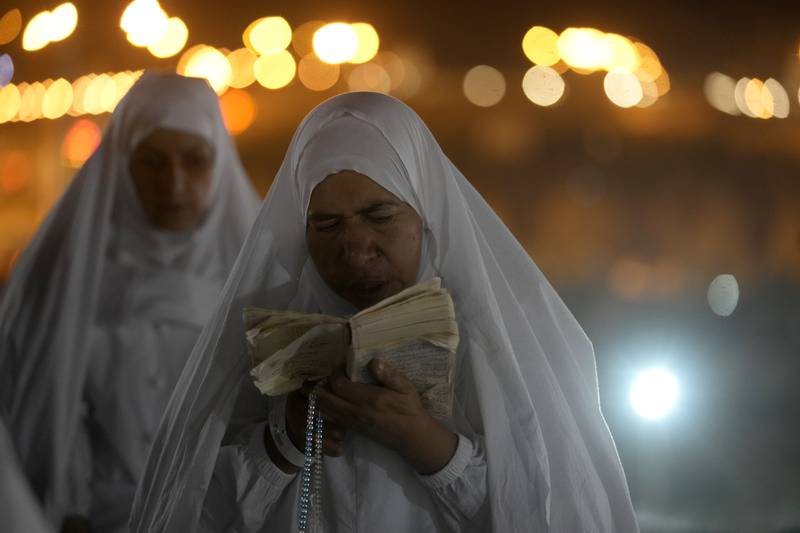 A female pilgrim reads the Quran on Mount Arafat. AP