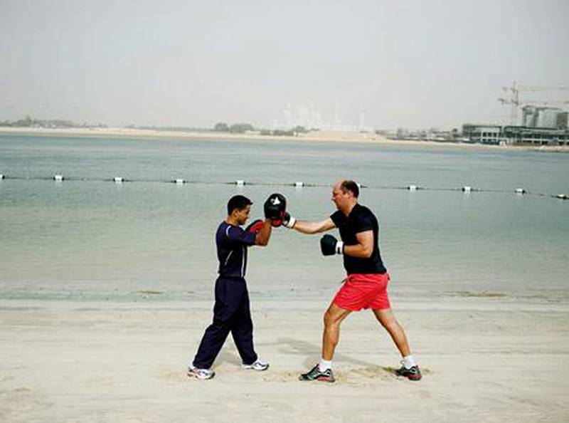 Abu Dhabi - August 5, 2009: Rupert Wright (right) undergoes four weeks of working out with the Shangri-La Hotel's personal trainer Hari P. Khatiwada (left), who is a former UAE boxing champion. . Lauren Lancaster / The National