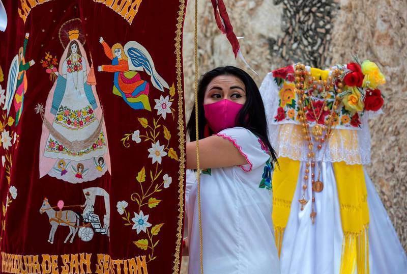 A woman takes part in the ceremony of delivery of a dress for the Virgin of the Assumption during the Catholic celebration of San Sebastian Mestizos Guild in Merida, Yucatan State, Mexico. AFP