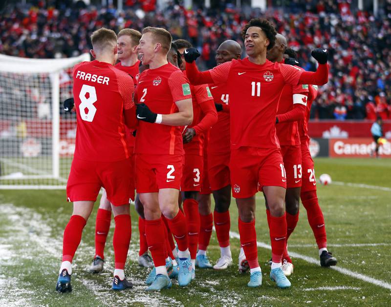 Canada players celebrate with Junior Hoilett after he scored the third goal against Jamaica. AFP