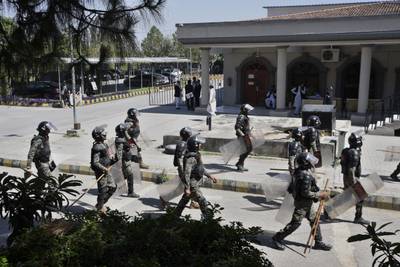 Pakistani paramilitary troops walk to the court where Mr Khan is appearing in Islamabad. AP