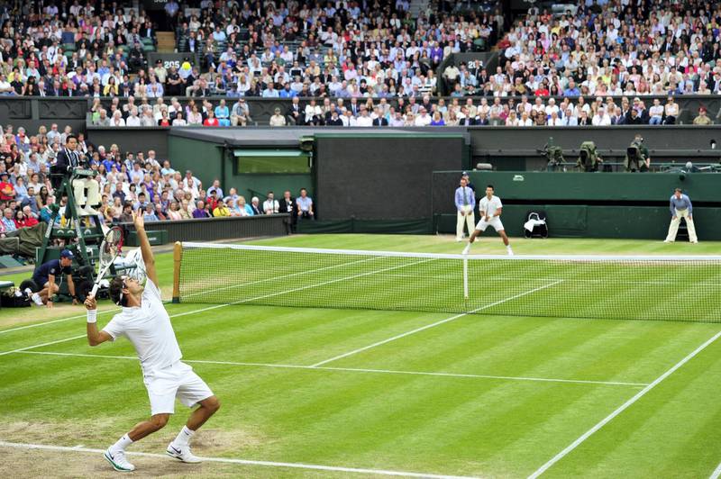 Switzerland's Roger Federer (L) serves during his men's singles semi-final victory over Serbia's Novak Djokovic on day 11 of the 2012 Wimbledon Championships tennis tournament at the All England Tennis Club in Wimbledon, southwest London, on July 6, 2012. AFP PHOTO / GLYN KIRK    RESTRICTED TO EDITORIAL USE (Photo by GLYN KIRK / AFP)