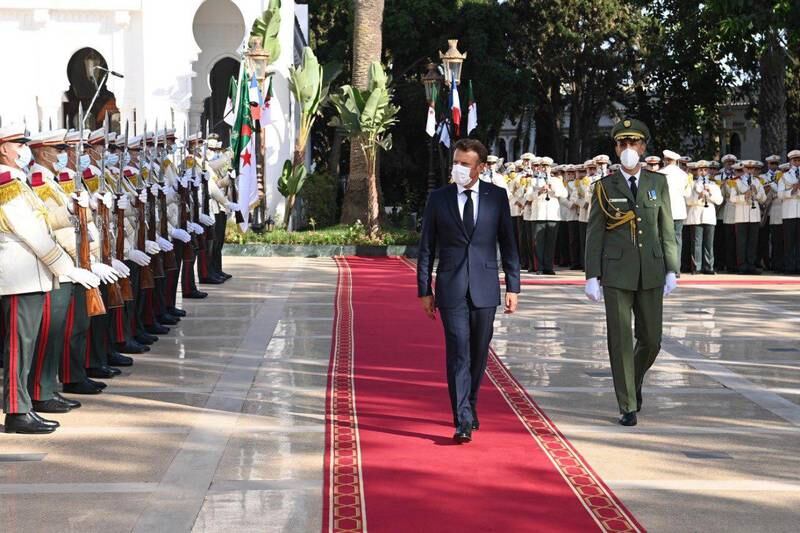 The French president reviews troops before talks with the Algerian leader. EPA