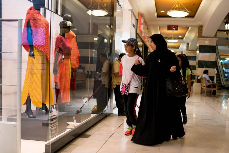 A family look at the window display of a fashion store while shopping at the Souq Sharq mall in Kuwait City, Kuwait, on Monday, Aug. 14, 2017. Kuwait will issue a tender to build the estimated $1.2 billion Dibdibah solar-power plant in the first quarter of 2018 as part of the country’s plans to produce 15 percent of power from renewable energy by 2030. Photographer: Tasneem Alsultan/Bloomberg
