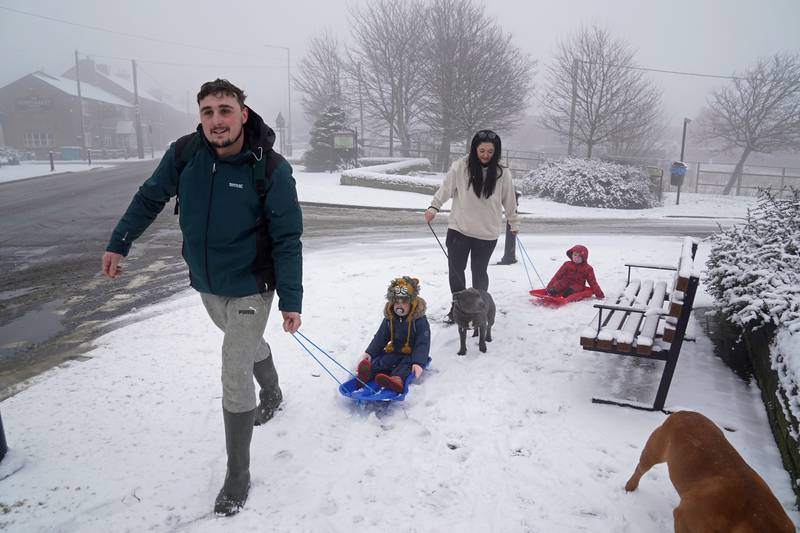 A family take advantage of the weather to have some fun on sledges in Tow Law, County Durham. PA