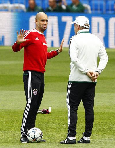 Bayern Munich manager Pep Guardiola, left, talks with assistant coach Hermann Gerland during their team's training session at Santiago Bernabeu stadium in Madrid, Spain on April 22, 2014. Bayern Munich will face Real Madrid in a Uefa Champions League semi final first leg match on Wednesday. EPA/BALLESTEROS