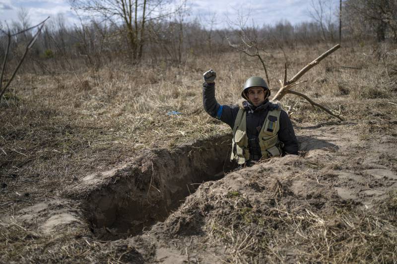 A soldier of the Ukrainian territorial defence forces gives a salute during a break in digging a foxhole at Kalynivka, on the outskirts of Kyiv, Ukraine. AP