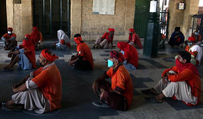 Porters waits to receive free ration distributed by Saylani trust as trains operations are shut amid lockdown due to the ongoing coronavirus COVID-19 pandemic, during the Muslim holy month of Ramadan in Karachi, Pakistan.  EPA