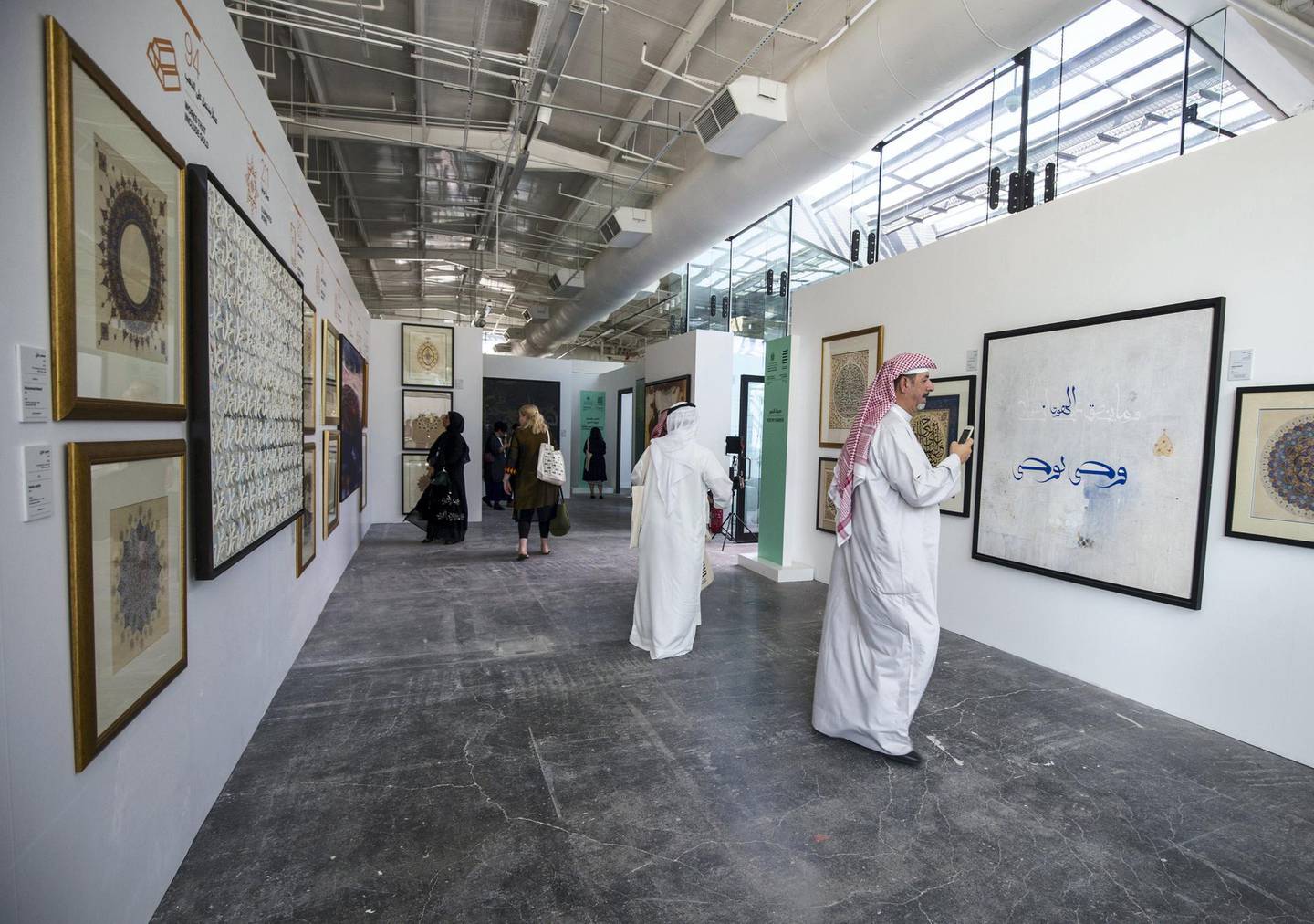 ABU DHABI, UNITED ARAB EMIRATES - Attendees looking at an art on display at the Al Burda Festival, Shaping the Future of Islamic Art and Culture at Warehouse 421, Abu Dhabi.  Leslie Pableo for The National for Melissa Gronlund’s story