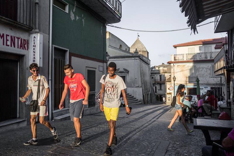 Young men from Riace walk towards the central streets of the village.The National/Giacomo Sini  