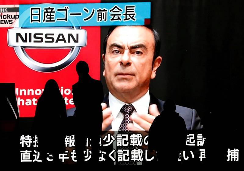 FILE PHOTO: Passersby are silhouetted as a huge street monitor broadcasts news reporting ousted Nissan Motor chairman Carlos Ghosn's indictment and re-arrest in Tokyo, Japan Dec. 10, 2018.  REUTERS/Issei Kato/File Photo
