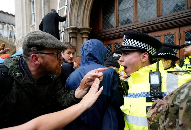 A protester and a police officer confront each other outside the Guildhall. AP Photo