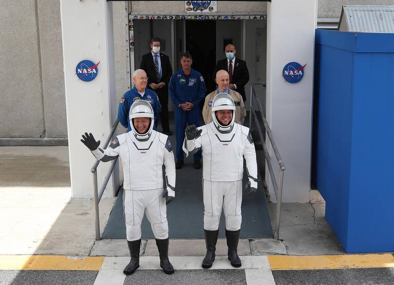 US astronauts Bob Behnken, right, and Doug Hurley walk out of the Operations and Checkout Building on their way to the SpaceX Falcon 9 rocket with the Crew Dragon spacecraft on launch pad 39A at the Kennedy Space Centre in Cape Canaveral, Florida, before their aborted space fligh on May 27, 2020. Getty Images