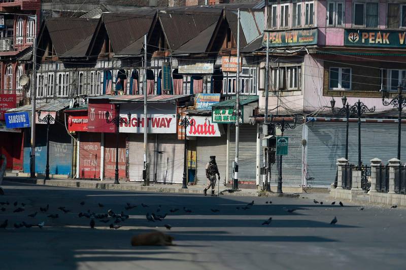 (FILES) In this file photo taken on September 8, 2019 an Indian paramilitary trooper patrols along an empty street during a strict curfew in Srinagar. The coffee machines have been cold, computer screens blank and work stations empty for two months in Kashmir's Silicon Valley as an Indian communications blockade on the troubled region takes a growing toll on business.
 / AFP / Tauseef MUSTAFA / To go with INDIA-KASHMIR-UNREST-POLITICS-ECONOMY,FOCUS
