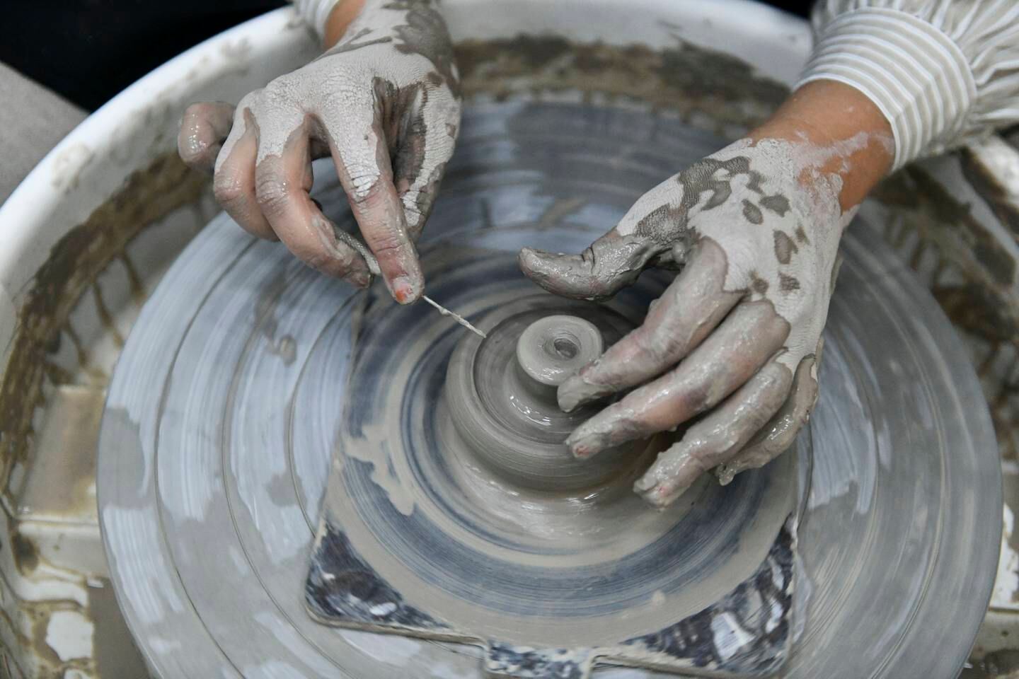 Sarah Al Hosani creates a teapot lid on a pottery wheel at Khazaf for Fine Arts studio, Mushrif. Khushnum Bhandari / The National
