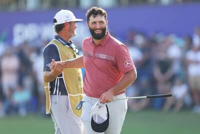 Jon Rahm of Spain shakes hands with his caddie, Adam Hayes on the 18th green. Getty Images