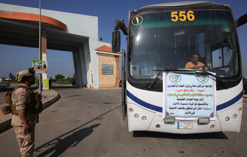 Iraqi soldiers secure buses transporting displaced families from the displaced persons camp in Habbaniyah. AFP