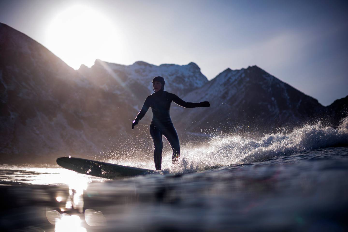 TOPSHOT - A surfer rides a wave on March 10, 2018 in Unstad, northern Norway, Lofoten islands, within the Arctic Circle as air temperature drops minus 13°C and water temperature above 4°C.  / AFP PHOTO / OLIVIER MORIN