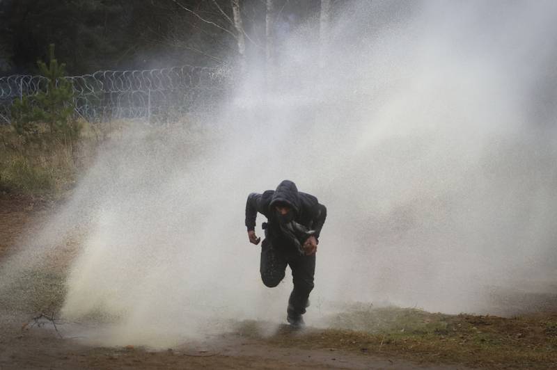 A man runs away from a water cannon during the clashes. AP Photo
