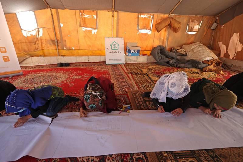 Syrian children draw and write messages on a paper roll during an event organised by the Shafak NGO in preparation for the International Day of Peace. All Photos: AFP