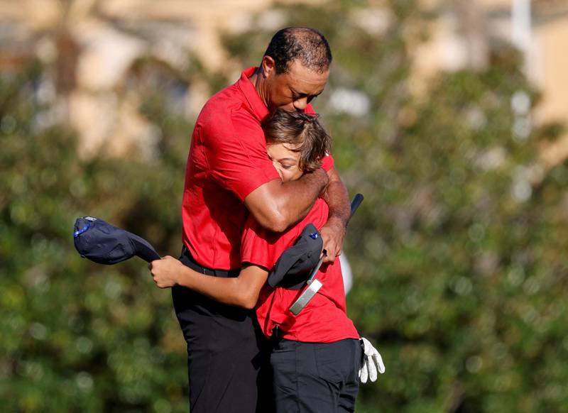 Tiger Woods embraces his son Charlie on the 18th green. Reuters