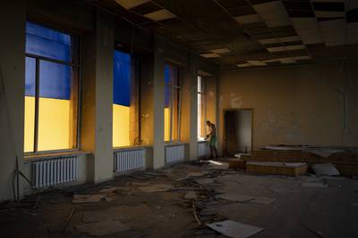A construction worker looks out of a damaged city council building in Izyum, Ukraine. AP