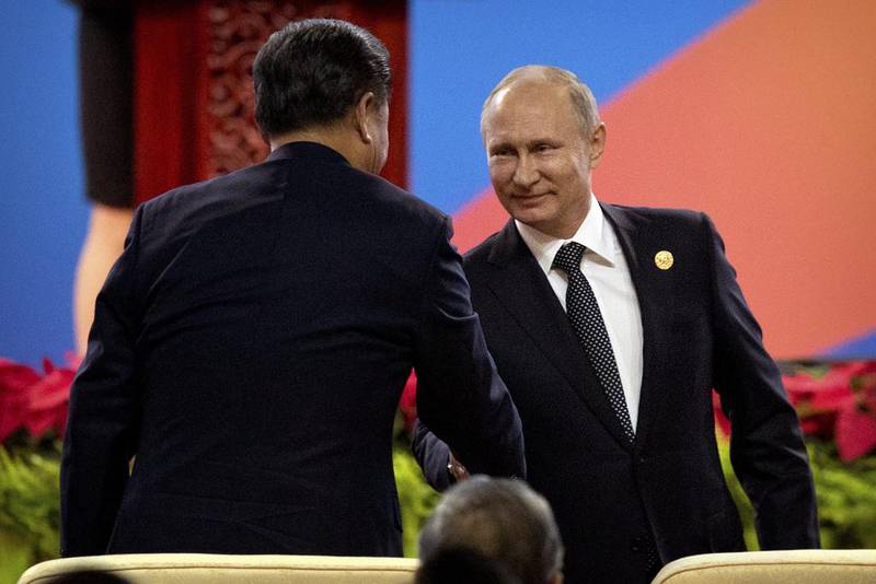 Chinese president Xi Jinping, left, shakes hands with Russian president Vladimir Putin. Mark Schiefelbein / AP Photo
