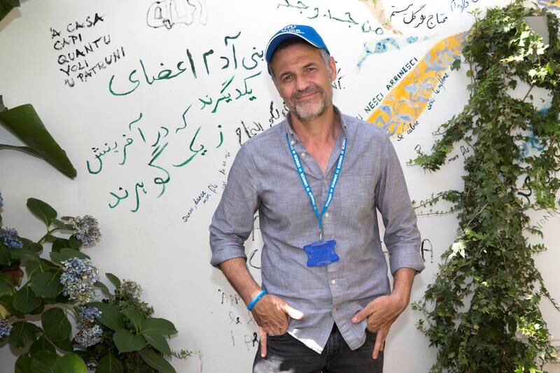 Khaled Hosseini writes a poem on the walls of of the Orient experience restaurant. ; UNHCR Goodwill Ambassador Khaled Hosseini meets refugees on the Italian island of Sicily. UNHCR/Andy Hall