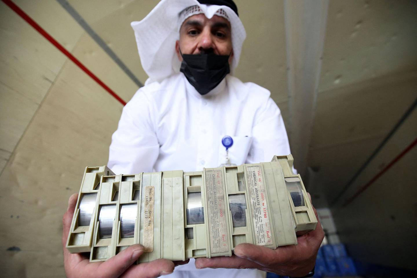 Employee at the Kuwaiti Information Ministry Essam al-Said inspects boxes in the back of a truck containing Kuwaiti archives seized during the Iraqi invasion of the Gulf emirate in 1990, after their restitution by Iraqi authorities in Kuwait City, on March 28, 2021. / AFP / YASSER AL-ZAYYAT
